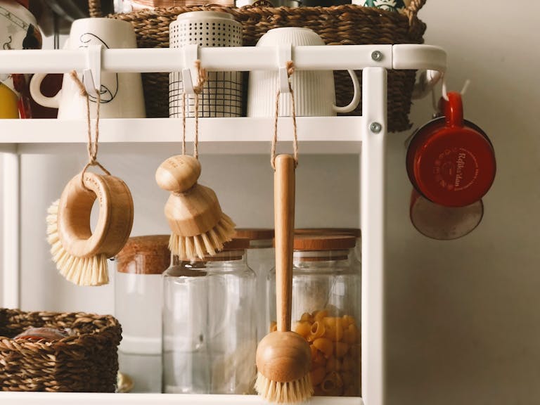 Minimalist kitchen rack with wooden brushes and storage jars in Scandi style.