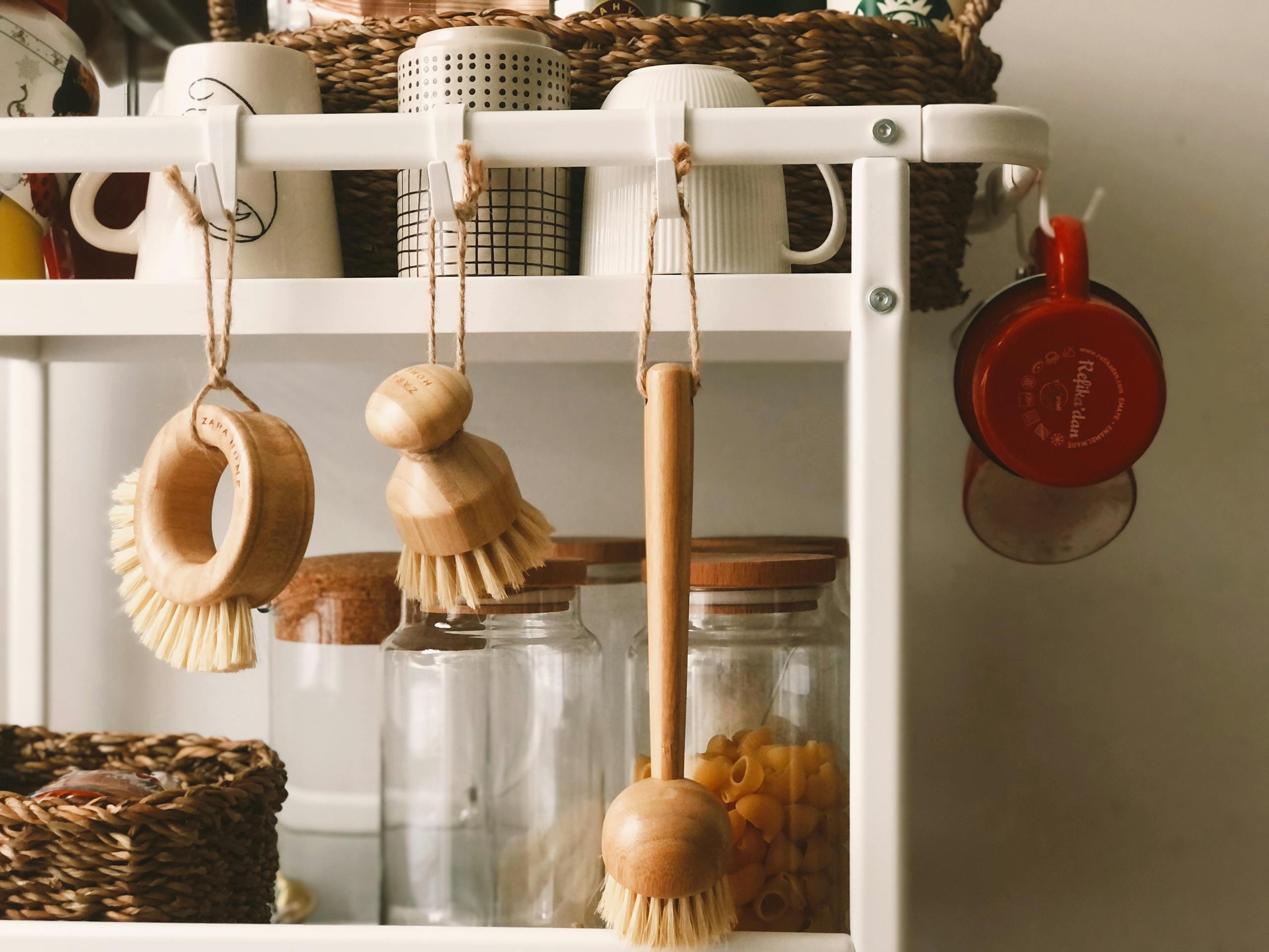 Minimalist kitchen rack with wooden brushes and storage jars in Scandi style.